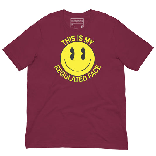 Maroon t-shirt with a large yellow smiley face graphic. Text above and below the face reads ‘This Is My Regulated Face,’ combining humor and neurodivergent pride.