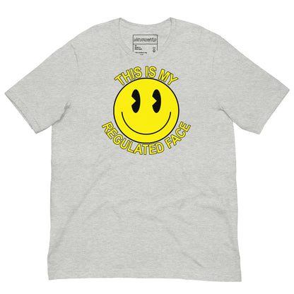 Gray t-shirt with a large yellow smiley face graphic. Text above and below the face reads ‘This Is My Regulated Face,’ combining humor and neurodivergent pride.