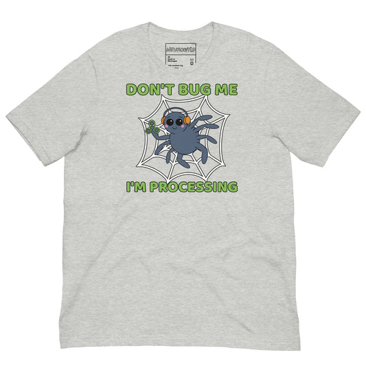 Light gray t-shirt featuring a cartoon spider sitting in a web, wearing orange headphones and holding a green fidget spinner. Above the spider, bold green text reads 'Don't Bug Me,' and below it says 'I'm Processing'.