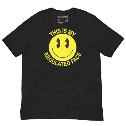 Black t-shirt with a large yellow smiley face graphic. Text above and below the face reads ‘This Is My Regulated Face,’ combining humor and neurodivergent pride.