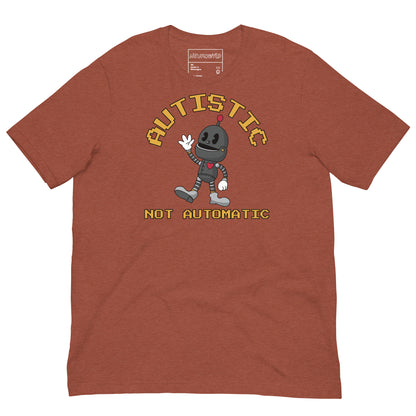 Clay t-shirt with a cartoon robot graphic and pixel-style text that reads ‘Autistic Not Automatic,’ celebrating neurodiversity with retro design flair.