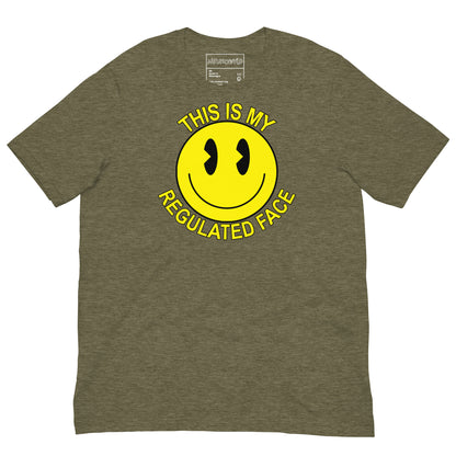 Green t-shirt with a large yellow smiley face graphic. Text above and below the face reads ‘This Is My Regulated Face,’ combining humor and neurodivergent pride.