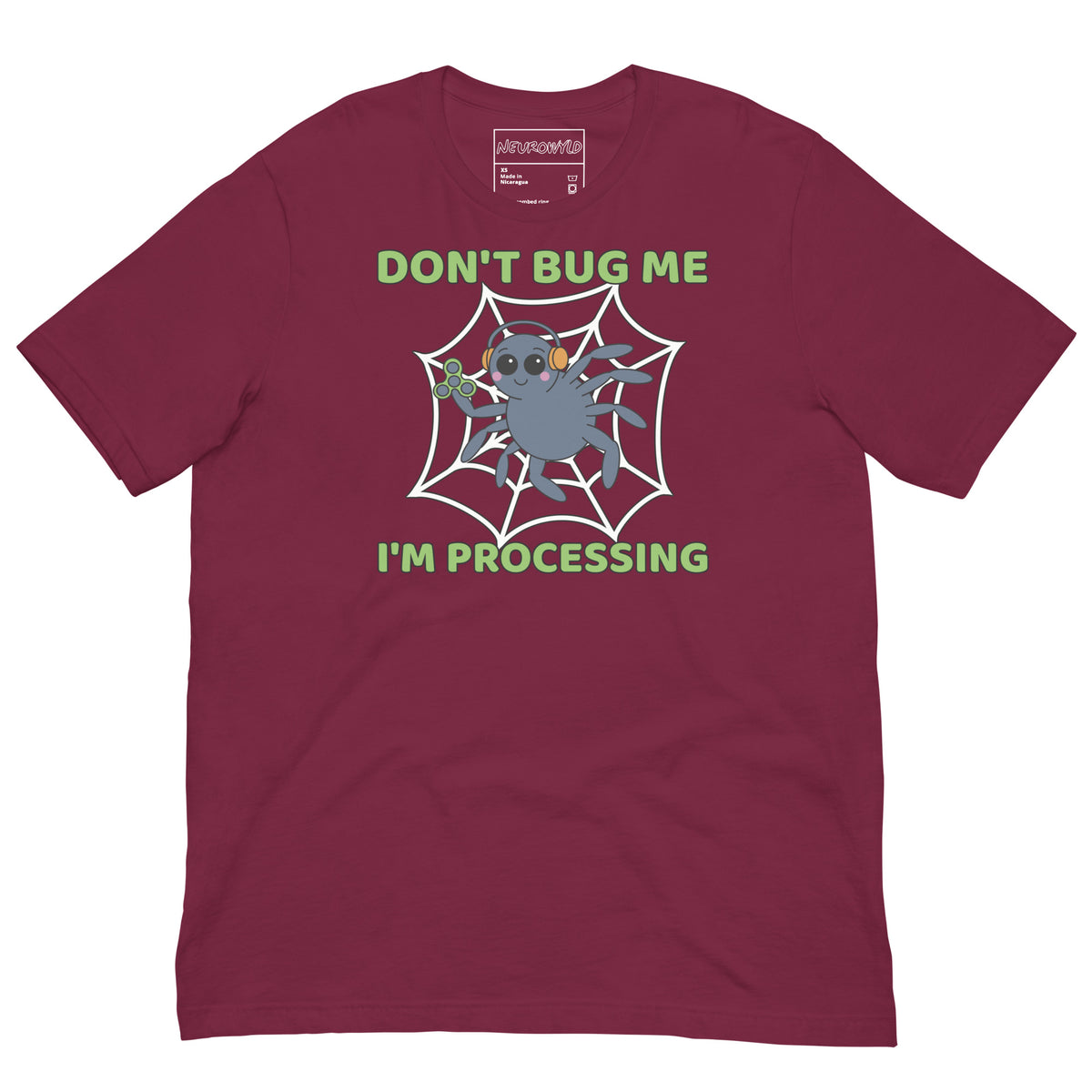 maroon t-shirt featuring a cartoon spider sitting in a web, wearing orange headphones and holding a green fidget spinner. Above the spider, bold green text reads 'Don't Bug Me,' and below it says 'I'm Processing'.