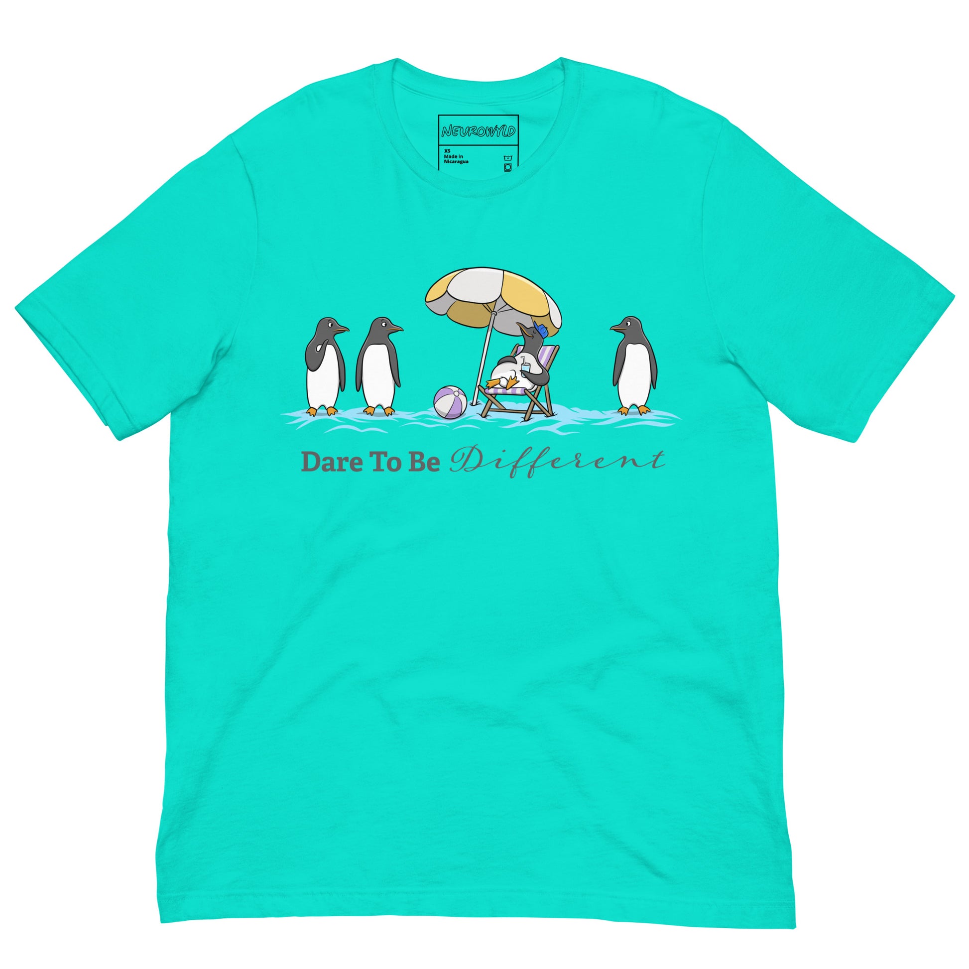 teal blue t-shirt featuring three penguins standing in a row while a fourth penguin lounges under a beach umbrella with a drink, surrounded by sand and a beach ball. Below the illustration, the text reads 'Dare To Be Different' in bold and script font.