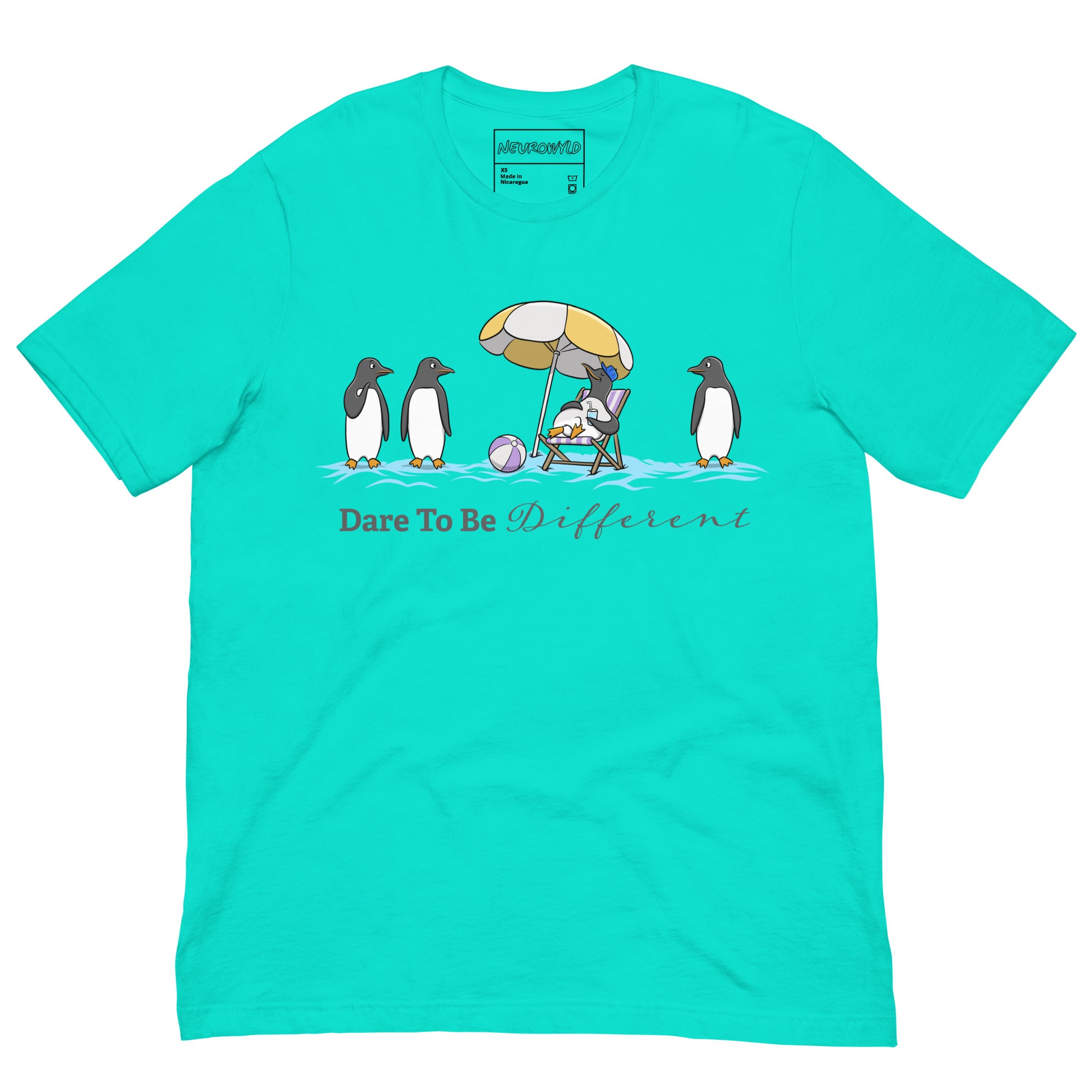 teal blue t-shirt featuring three penguins standing in a row while a fourth penguin lounges under a beach umbrella with a drink, surrounded by sand and a beach ball. Below the illustration, the text reads 'Dare To Be Different' in bold and script font.