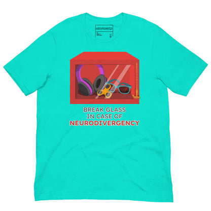 Bright teal t-shirt featuring a red emergency box illustration filled with noise-canceling headphones, a fidget spinner, sunglasses, and a small anchor. Below the box, bold text reads 'Break Glass in Case of Neurodivergency' with 'Neurodivergency' highlighted in red.