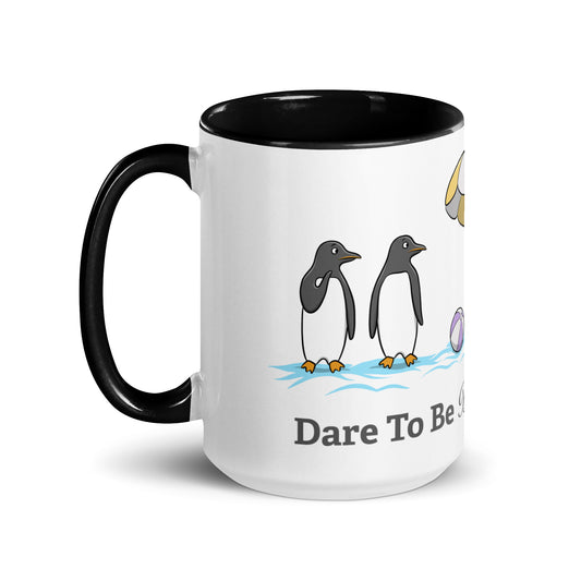 White ceramic mug with black interior featuring a beach scene of penguins and the phrase “Dare To Be Different” — playful neurodivergent identity design